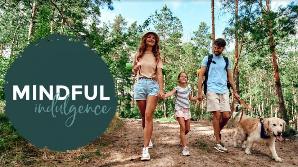 family walking with dog on nature trail