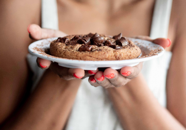 woman holding plate with cookie