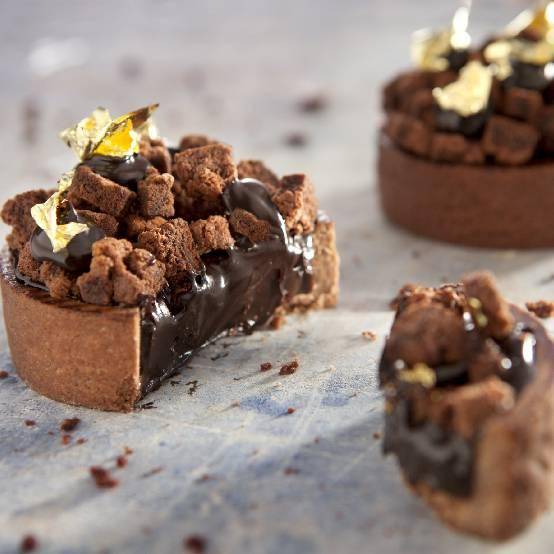 Choco Tartelettes with chocolate filling, brownie pieces and a touch of gold, made by Chef Martin Diez. 