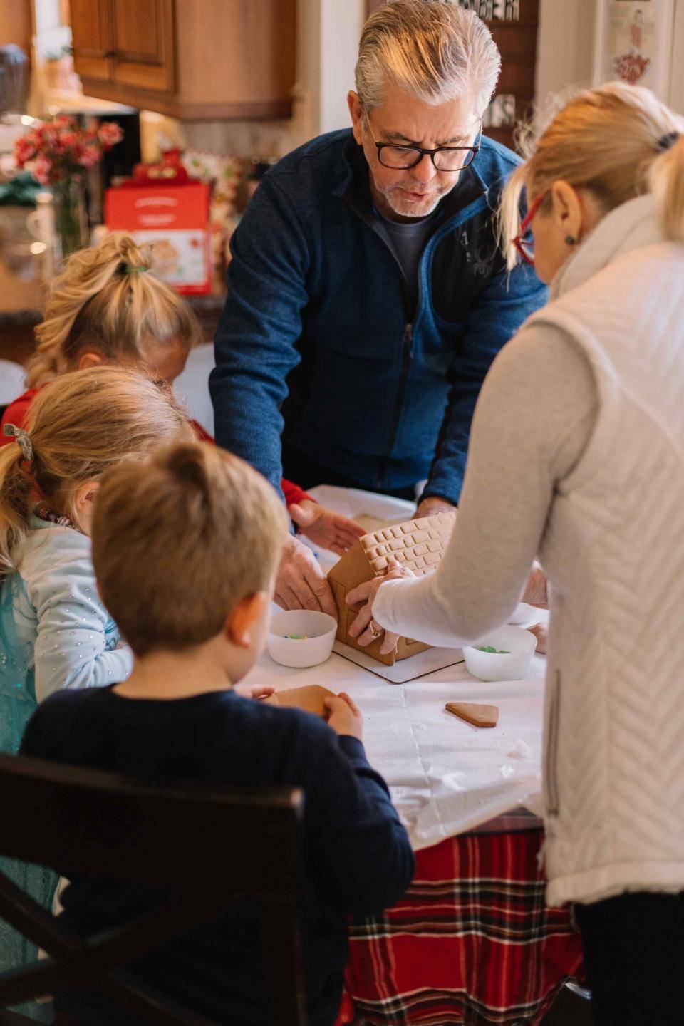 Grandparents creating gingerbread house with grandchildren. Photo by Phillip Goldsberry on Unsplash.