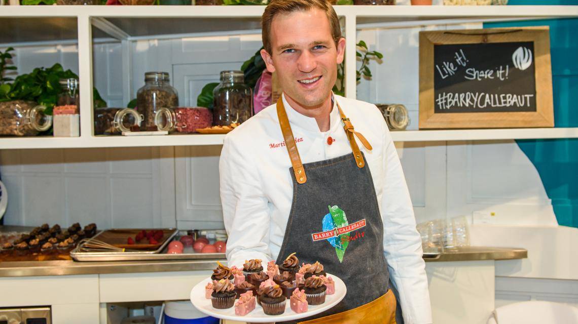A BC Studio Chef holds out a plate with all the chocolate creations offered at the booth