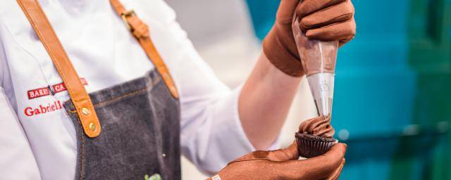 A BC Studio chef frosts a cupcake made with Bensdorp Natural Dark cocoa powder