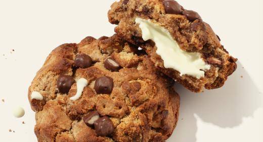 Chocolate chip cookie with filling on a cream background