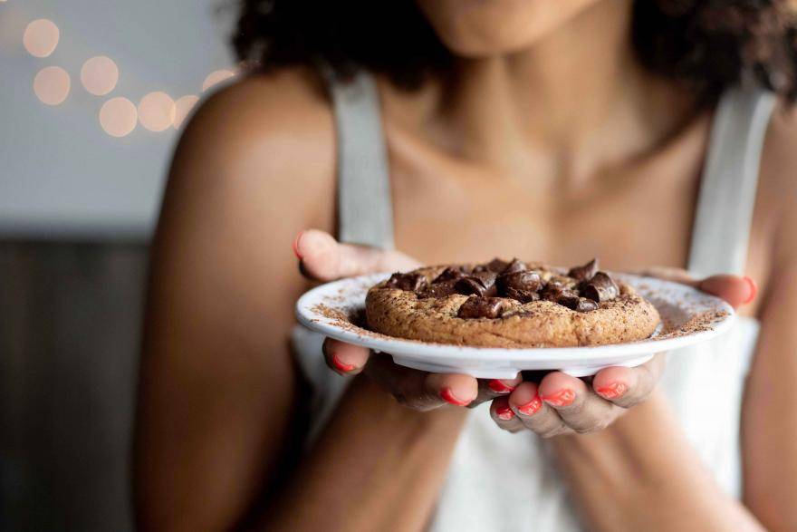 woman holding cookie on a plate