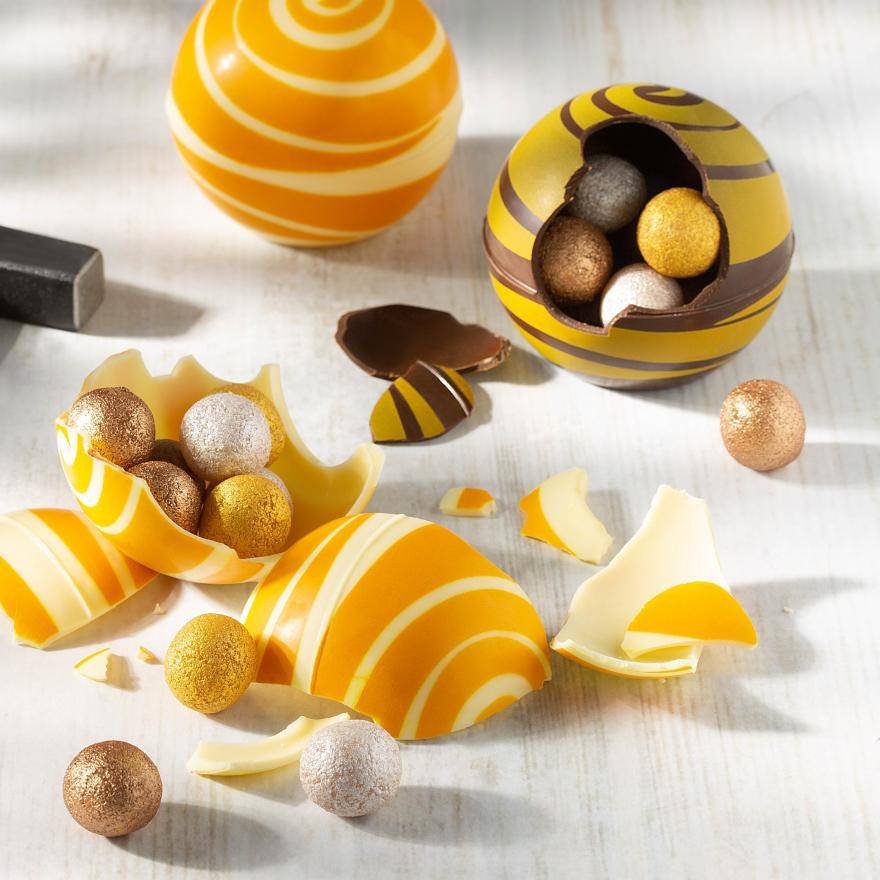 Dessert shell pinatas filled with colored rolled truffle shells