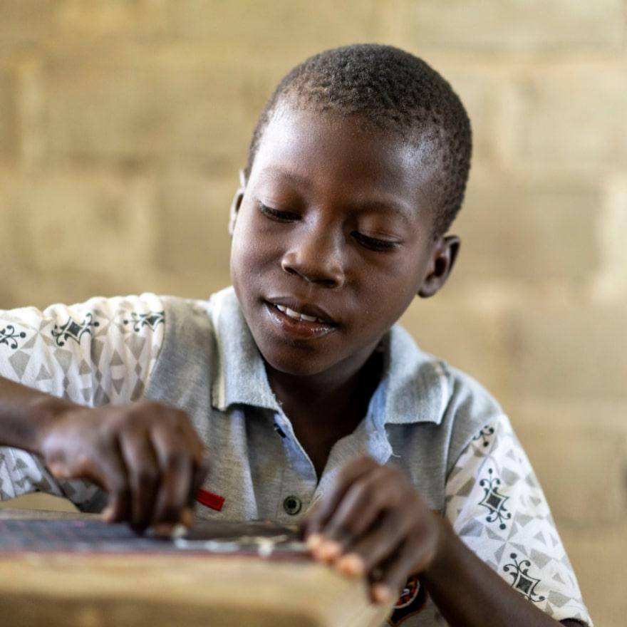 child writing at a desk