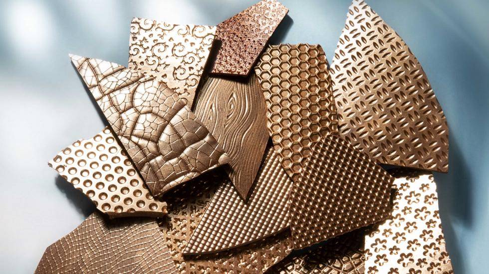 Various textured dark chocolate slabs with a bronze finish