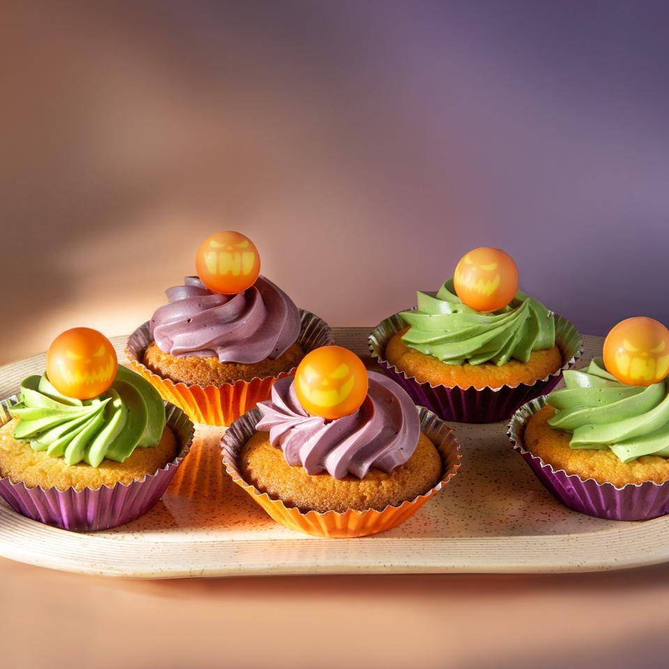Cupcakes with colored frosting and chocolate pumpkin decorations