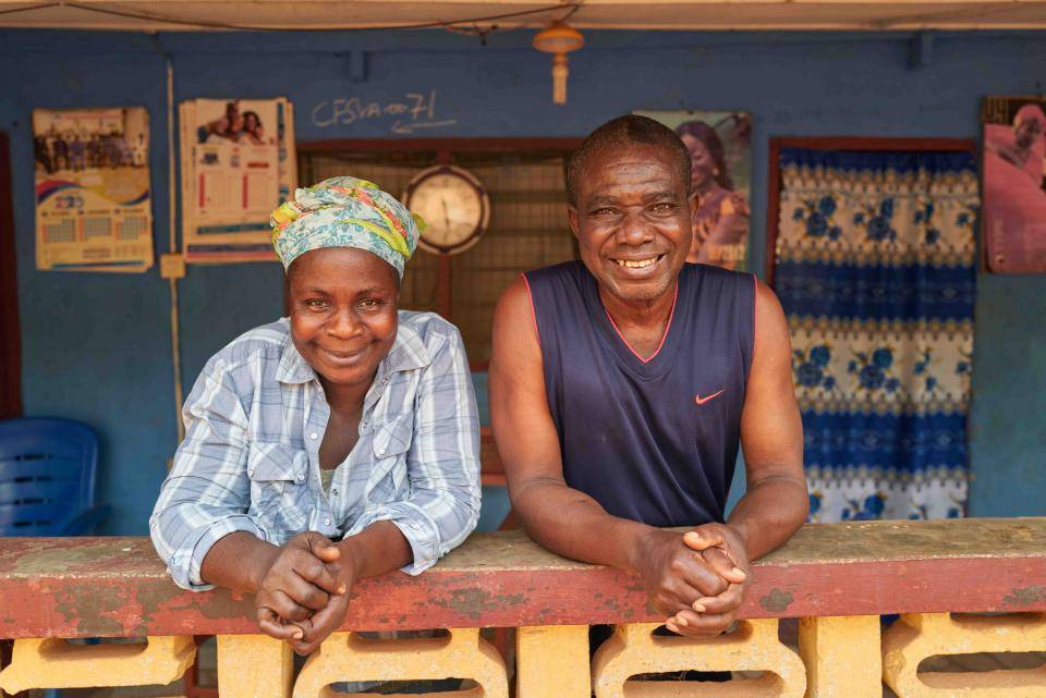 Cocoa farmers couple in front of their house