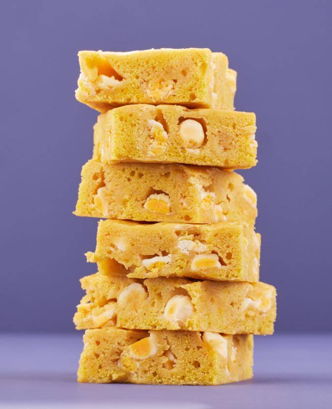 blondies stacked in front of a purple background