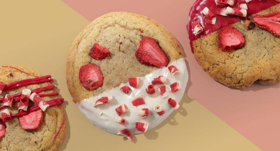 Cookies with strawberries and frosting on a multi-colored background