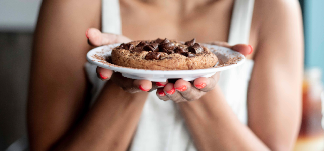 woman holding plate with cookie