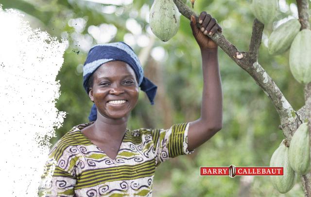 woman smiling holding onto cacao plant branch